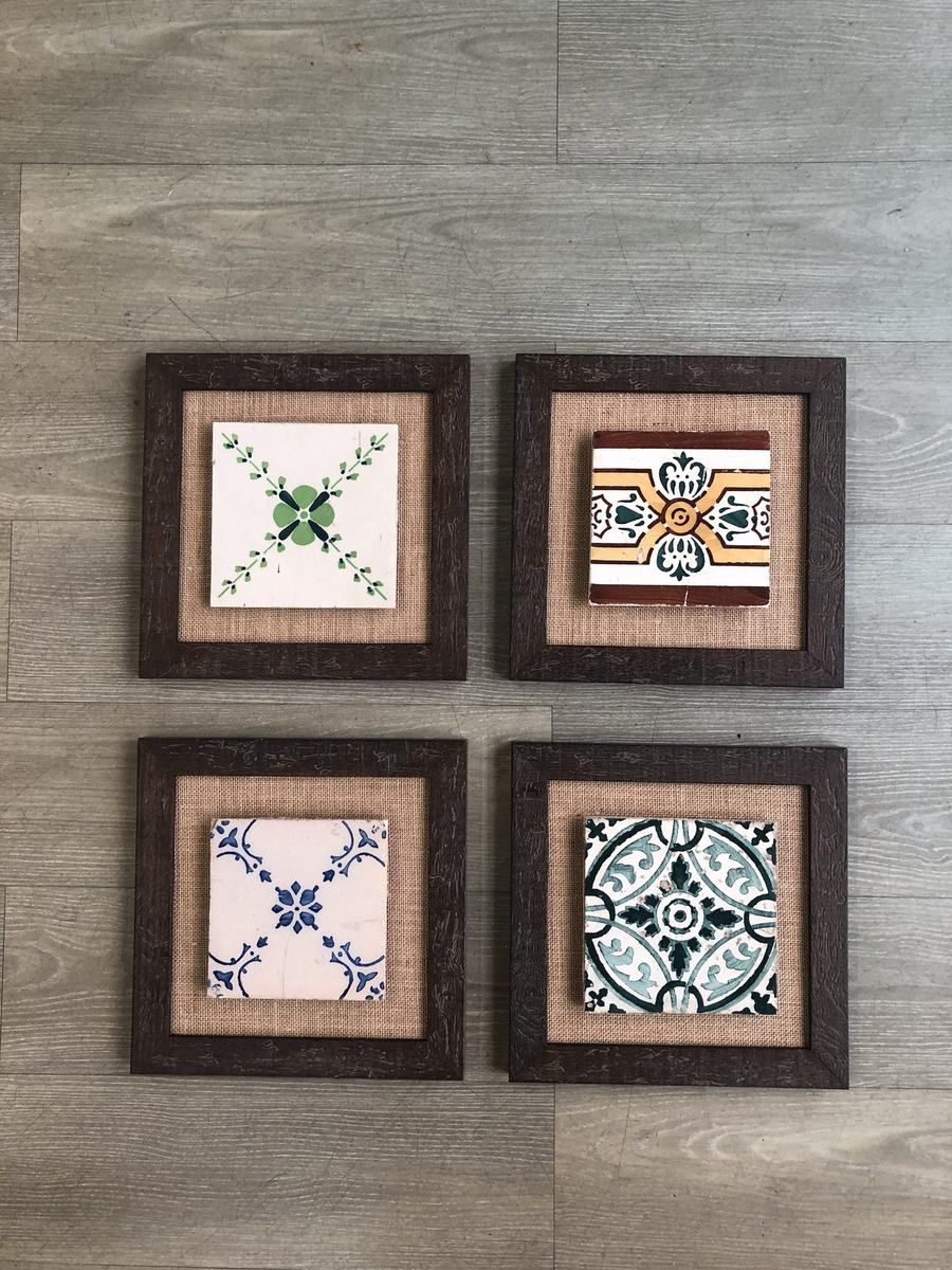 Four individually framed decorative ceramic tiles